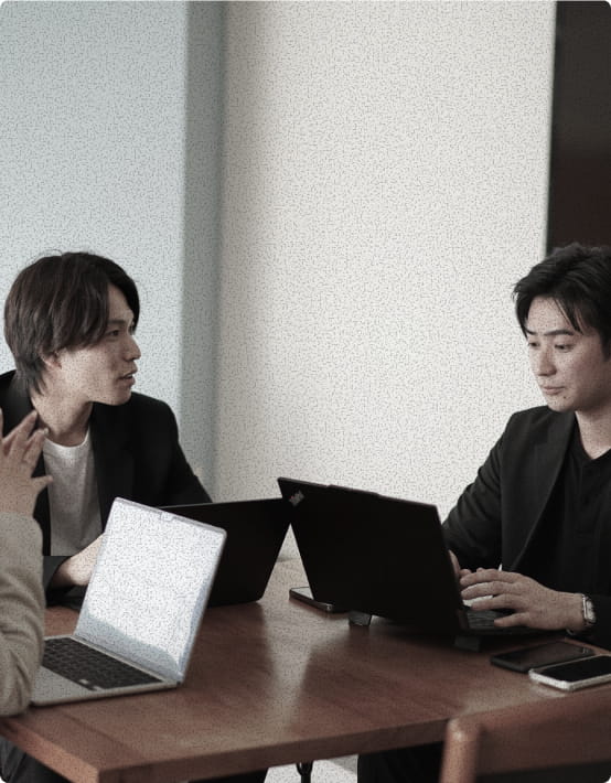 デスクで打ち合わせをする社員たち