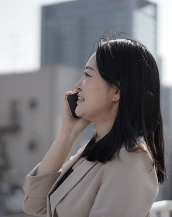 屋外で電話をする社員